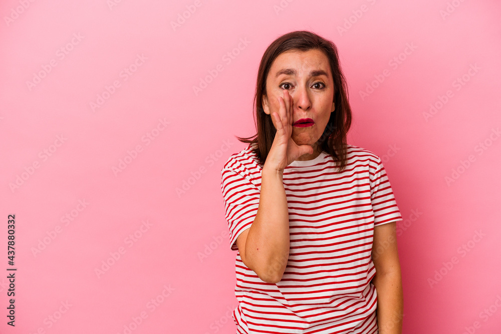 Middle age caucasian woman isolated on pink background is saying a secret hot braking news and looking aside Middle age caucasian woman isolated on pink background is saying a secret hot braking news and looking aside