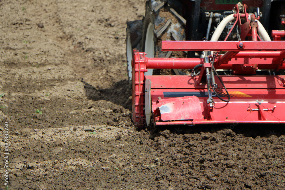 Obraz premium 畑を耕すトラクター