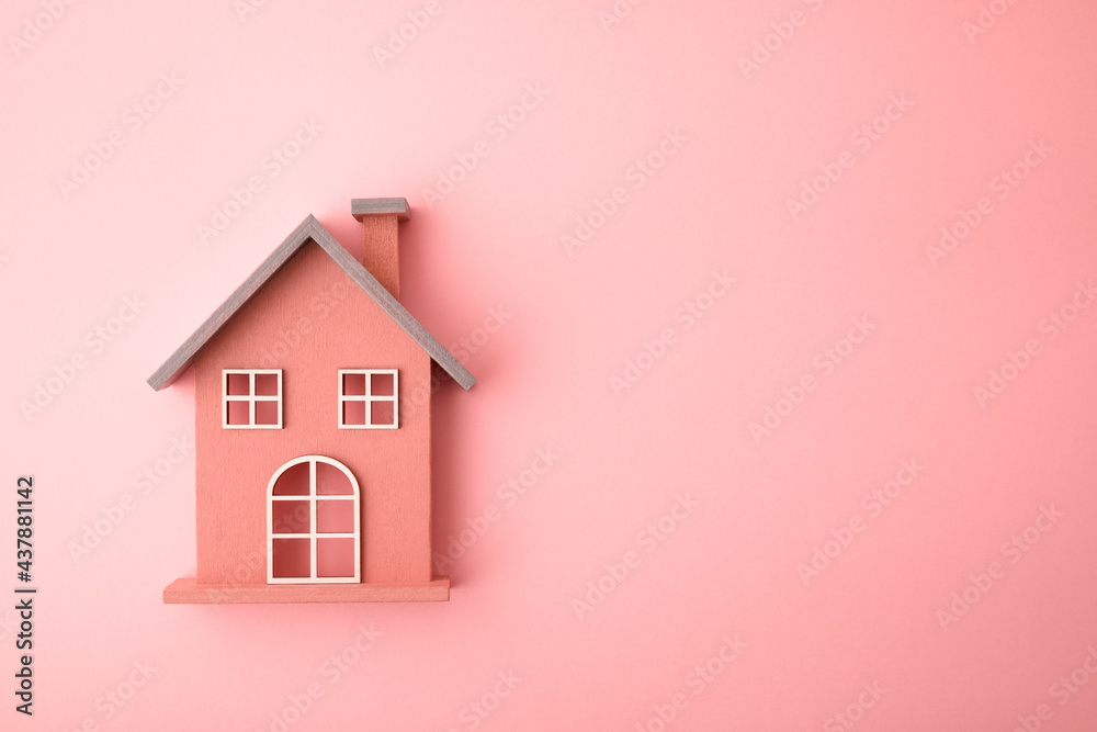 Small wooden toy house on pink background - obrazy, fototapety, plakaty 