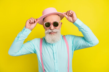 Photo portrait of old man wearing sunglass smiling cheerful in shirt suspenders isolated vibrant yellow color background