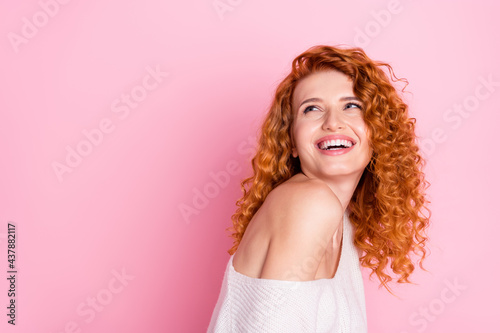 Photo portrait of red curly haired girl smiling with off-shoulder laughing looking blank space isolated pastel pink color background