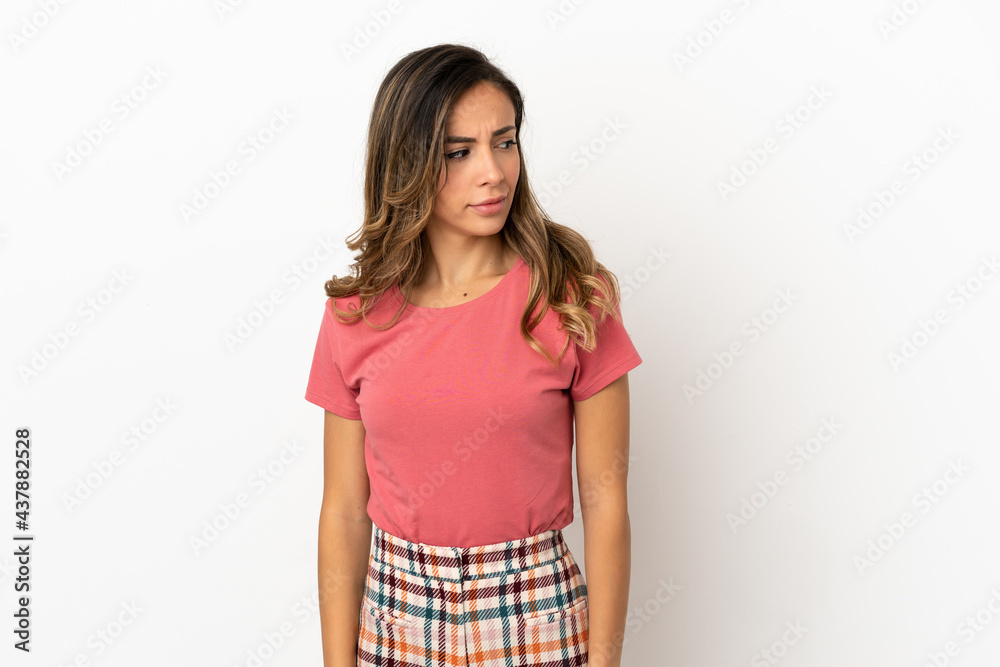 Young woman over isolated background having doubts while looking side Young woman over isolated background having doubts while looking side