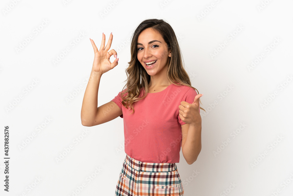 Young woman over isolated background showing ok sign and thumb up gesture Young woman over isolated background showing ok sign and thumb up gesture