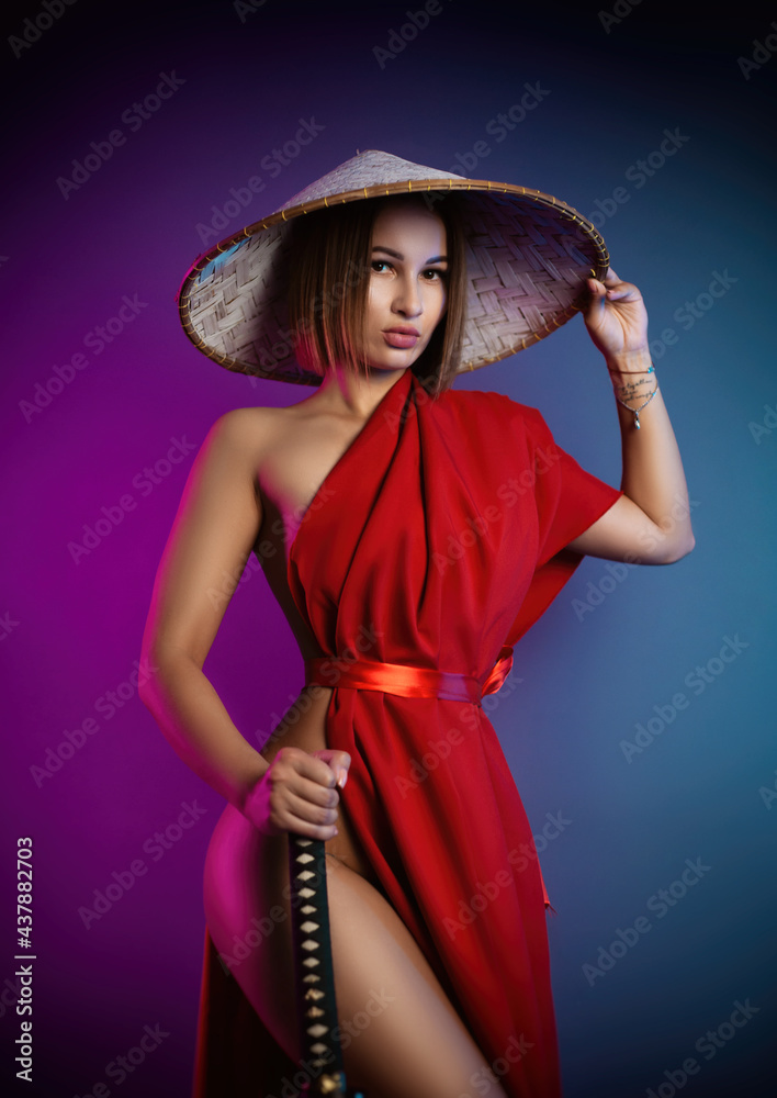 Sexy Woman In A Red Cape And An Asian Hat With A Katana In Her Hand