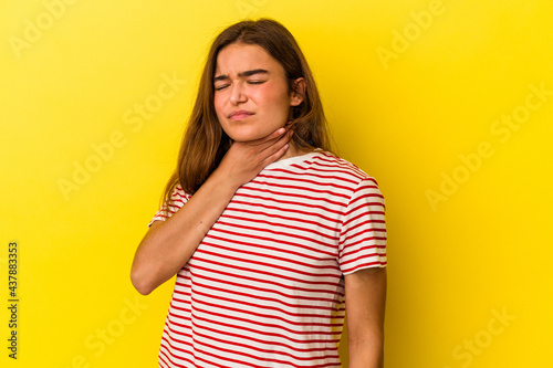 Young caucasian woman isolated on yellow background suffers pain in throat due a virus or infection.