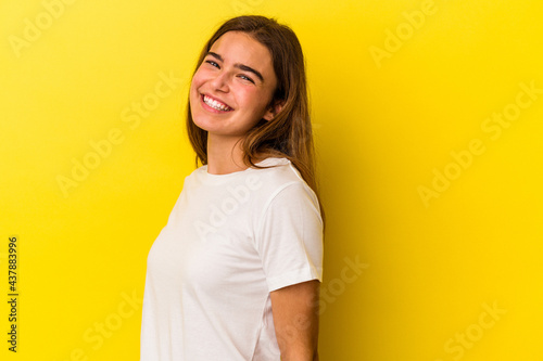 Young caucasian woman isolated on yellow background confident keeping hands on hips.