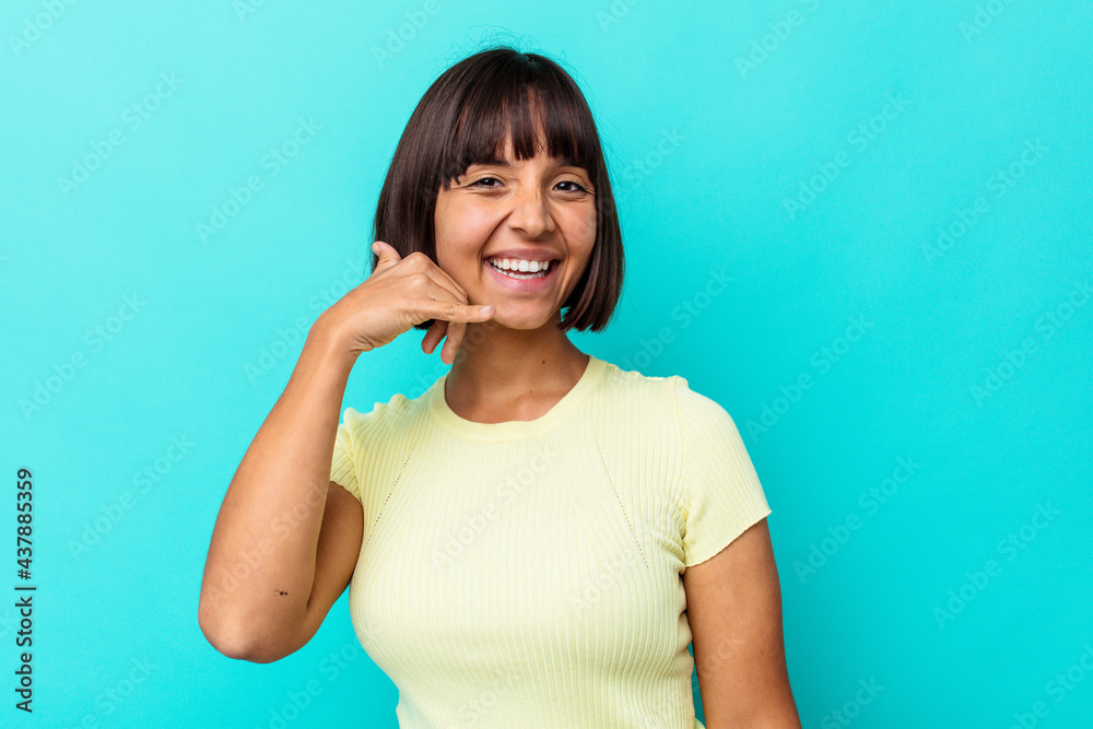 Young mixed race woman isolated on blue background showing a mobile phone call gesture with fingers. Young mixed race woman isolated on blue background showing a mobile phone call gesture with fingers.