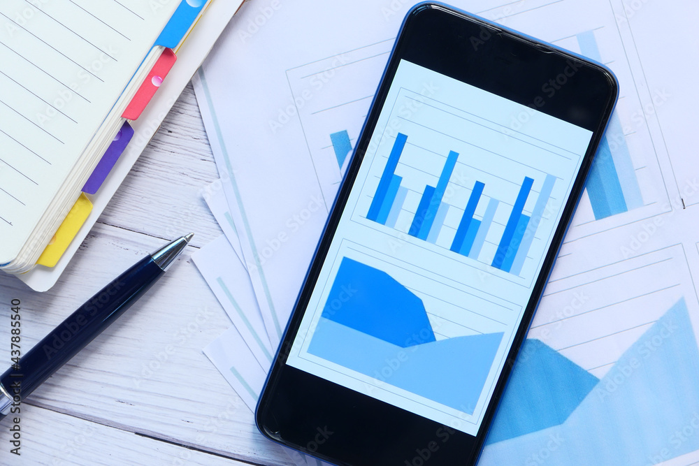 financial charts display on smart phone on table financial charts display on smart phone on table