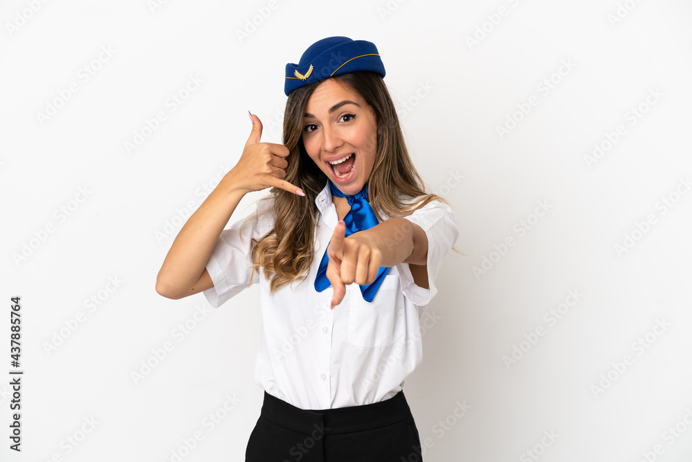 Airplane stewardess over isolated white background making phone gesture and pointing front Airplane stewardess over isolated white background making phone gesture and pointing front