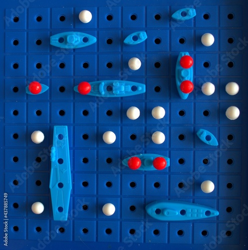 Children's game sea battle. Blue field and blue ships. There is a battle going on. Dead ships. The battlefield
