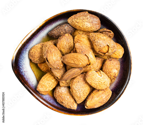 almond seeds and drupes in ceramic bowl isolated