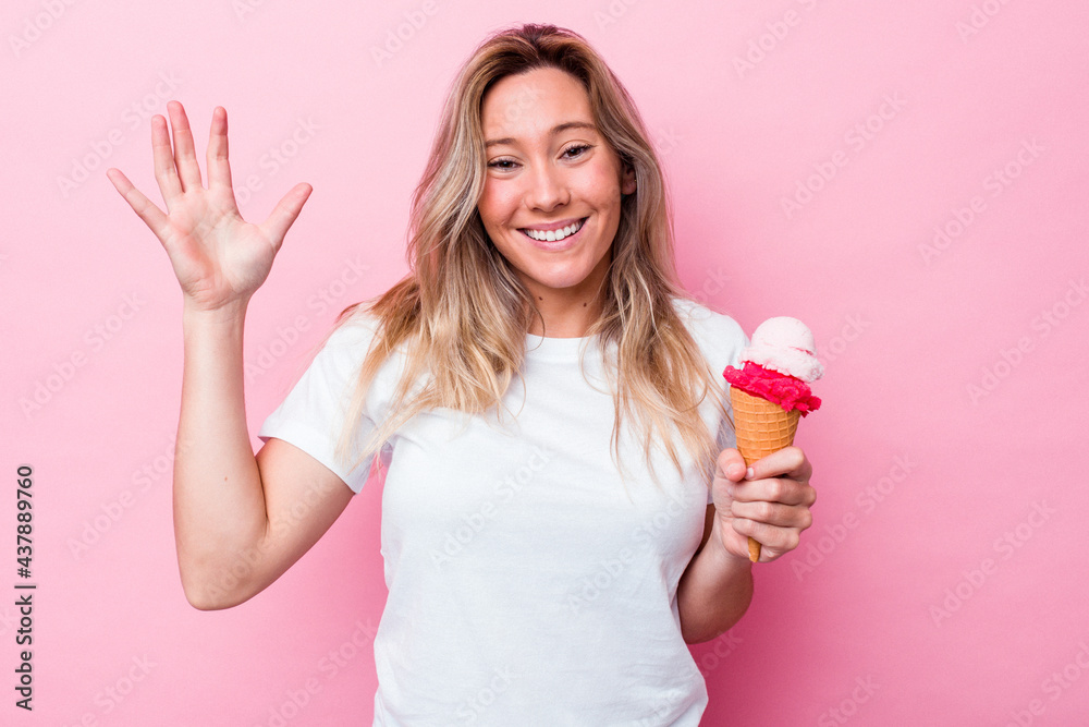 Young australian woman holding an ice cream isolated on pink background receiving a pleasant surprise, excited and raising hands. Young australian woman holding an ice cream isolated on pink background receiving a pleasant surprise, excited and raising hands.