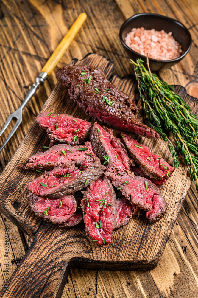 Sliced grilled machete skirt meat beef steak on a wooden cutting board. wooden background. Top view