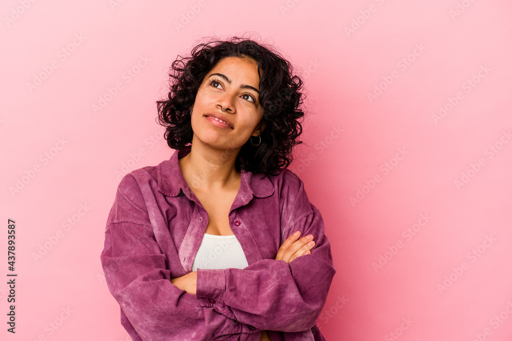 Young curly latin woman isolated on pink background dreaming of achieving goals and purposes Young curly latin woman isolated on pink background dreaming of achieving goals and purposes