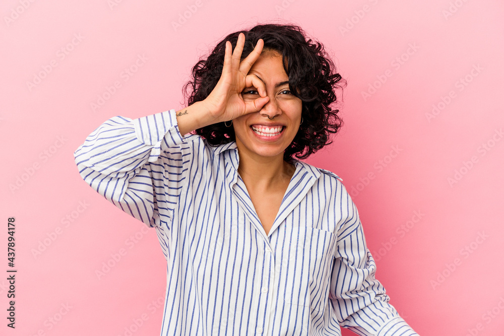 Young curly latin woman isolated on pink background excited keeping ok gesture on eye. Young curly latin woman isolated on pink background excited keeping ok gesture on eye.