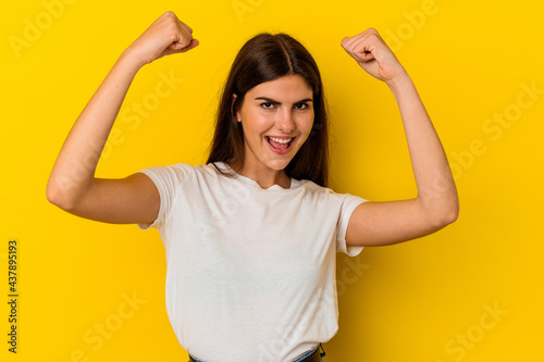Young caucasian woman isolated on yellow background cheering carefree and excited. Victory concept.