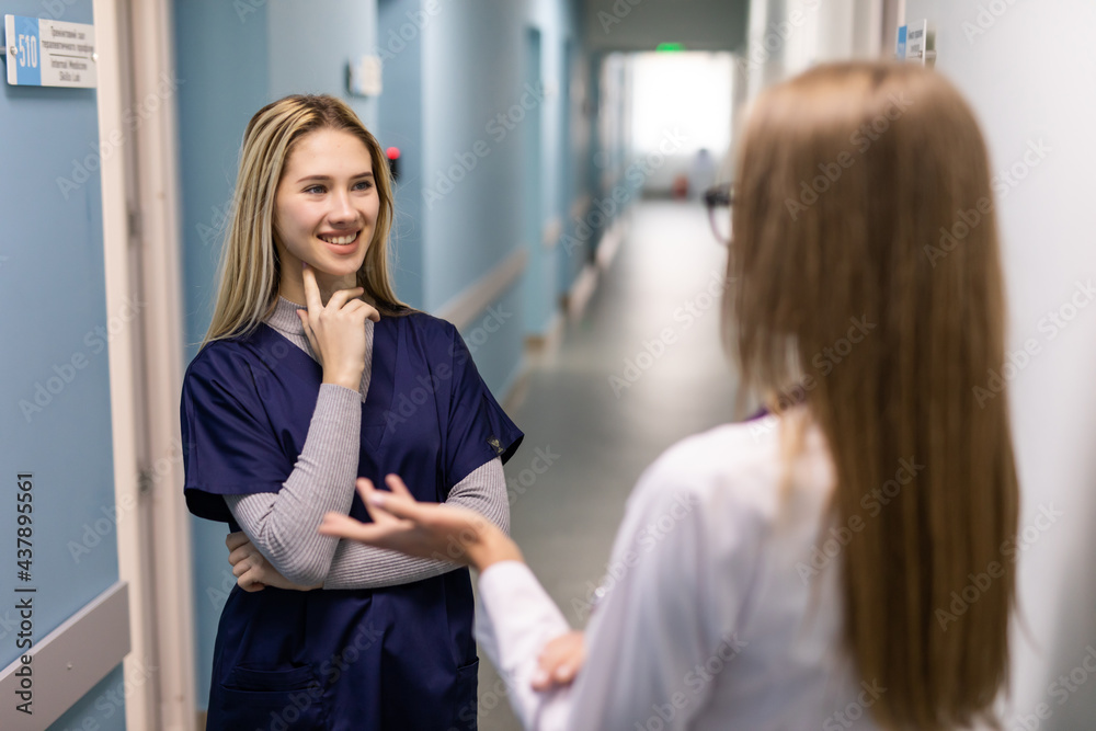 Two woman doctor with mask talking in hospital corridor, health care. female doctors examining a file in a bright office. Two woman doctor with mask talking in hospital corridor, health care. female doctors examining a file in a bright office.