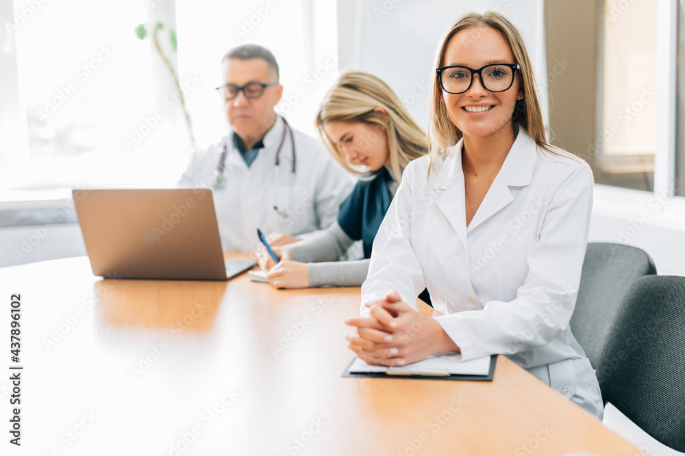Medical Team Meeting Around Table In Modern Hospital Medical Team Meeting Around Table In Modern Hospital