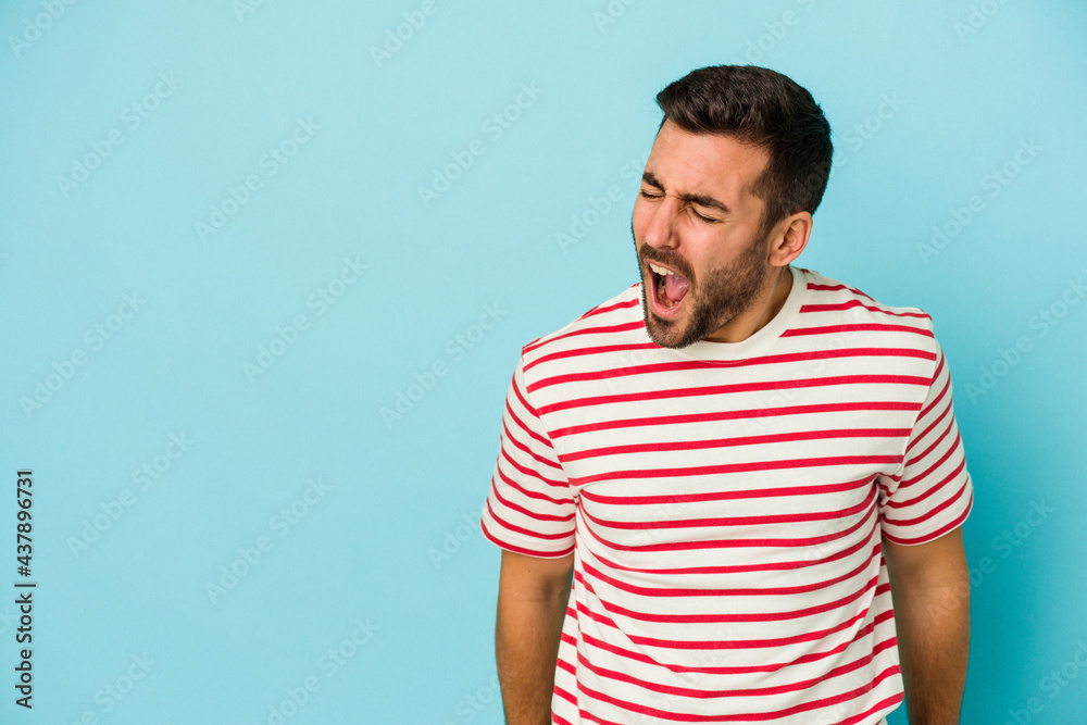 Young caucasian man isolated on blue background shouting very angry, rage concept, frustrated. Young caucasian man isolated on blue background shouting very angry, rage concept, frustrated.