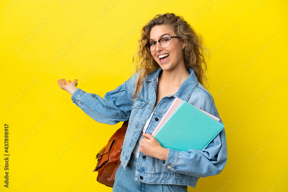 Young student caucasian woman isolated on yellow background extending hands to the side for inviting to come Young student caucasian woman isolated on yellow background extending hands to the side for inviting to come