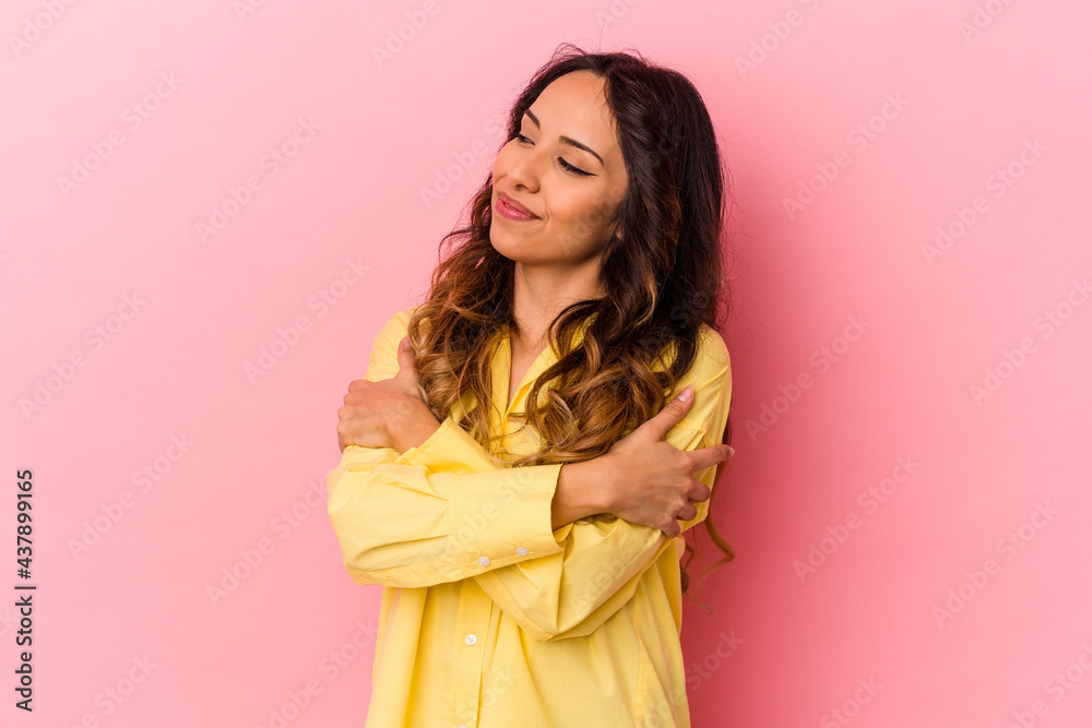 Young mexican woman isolated on pink background hugs, smiling carefree and happy. Young mexican woman isolated on pink background hugs, smiling carefree and happy.