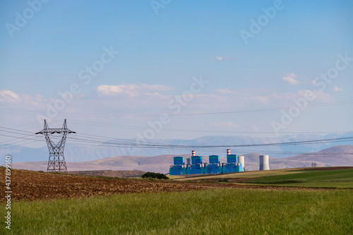 Steaming cooling towers on green meadow