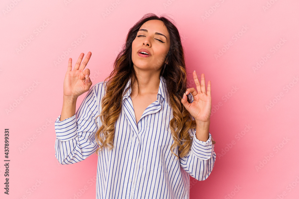 Young mexican woman isolated on pink background relaxes after hard working day, she is performing yoga. Young mexican woman isolated on pink background relaxes after hard working day, she is performing yoga.