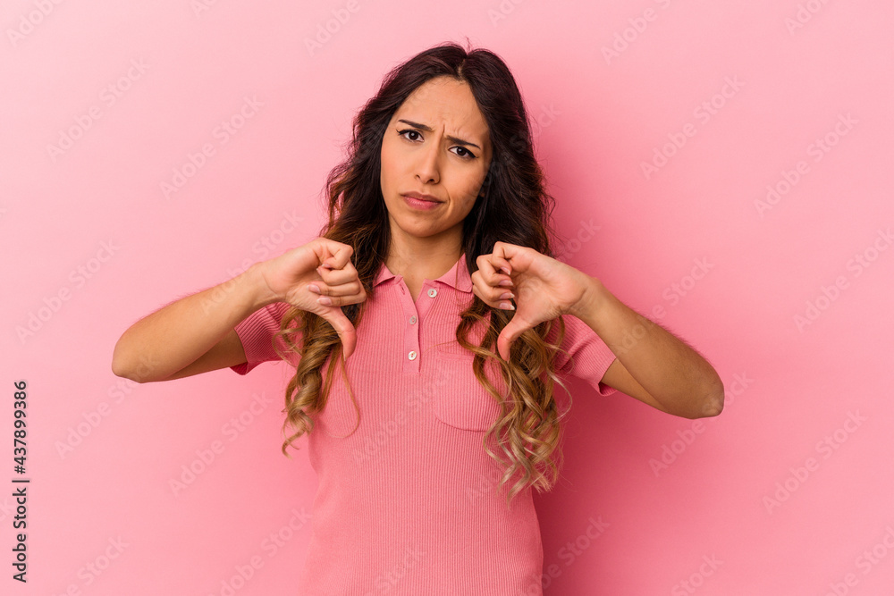 Young mexican woman isolated on pink background showing thumb down, disappointment concept. Young mexican woman isolated on pink background showing thumb down, disappointment concept.