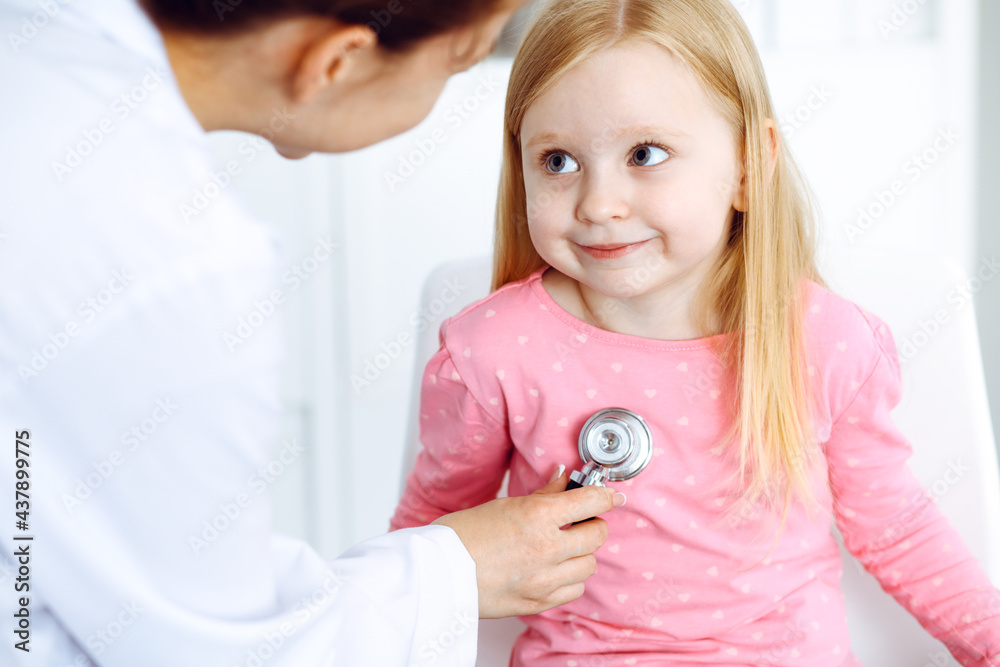 Fototapeta premium Happy smiling female kid-patient at usual medical inspection. Doctor and young girl in the clinic. Medicine, healthcare concepts
