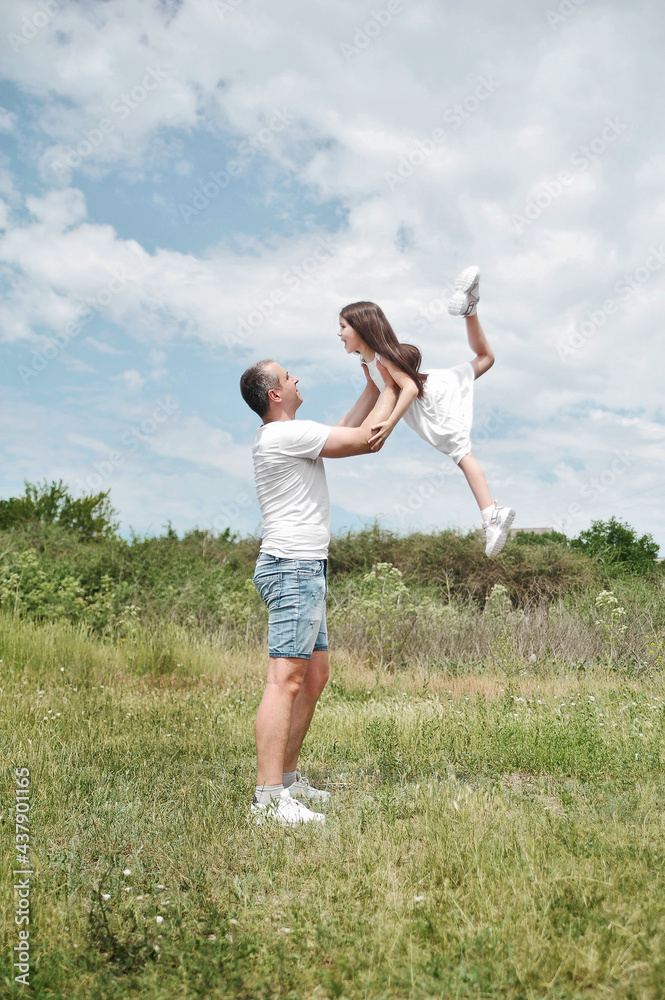 Fototapeta premium Parent and child. Father has fun with his daughter outdoors.