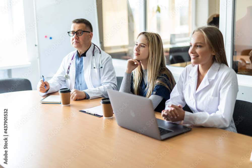 Medical team interacting at a meeting in conference room in modern hospital Medical team interacting at a meeting in conference room in modern hospital