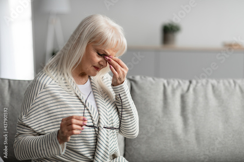 Tired mature woman rubbing dry irritated eyes photo