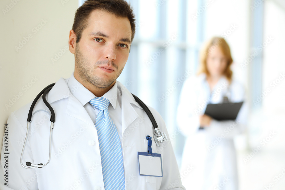 Male doctor standing in the modern clinic. Perfect medical service in the hospital. Medicine and healthcare concept Male doctor standing in the modern clinic. Perfect medical service in the hospital. Medicine and healthcare concept