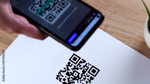 Hand holding smart phone to scan QR code payment. The concept of cashless technology or digital payment.