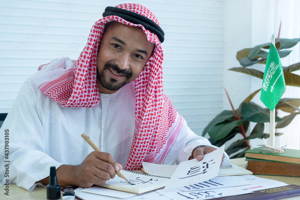 Arab men practicing writing Arabic ้with bamboo pens and ink on paper