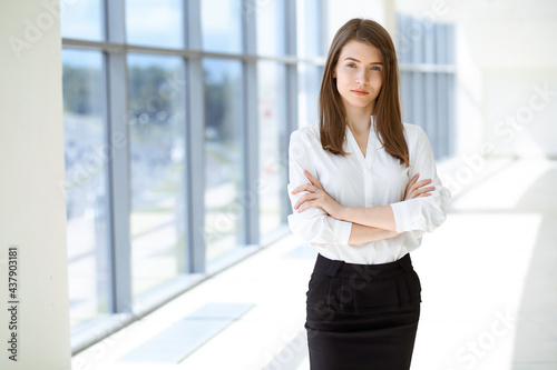 Beautiful female specialist with arms crossed standing in modern office and smiling charmingly. Working on design, data analysis, plan strategy. Business people concept Free Download Beautiful female specialist with arms crossed standing in modern office and smiling charmingly. Working on design, data analysis, plan strategy. Business people concept - GFXLoad