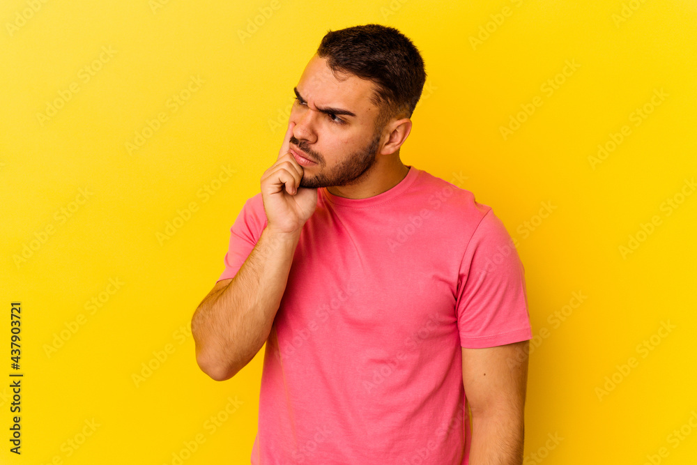 Young caucasian man isolated on yellow background contemplating, planning a strategy, thinking about the way of a business. Young caucasian man isolated on yellow background contemplating, planning a strategy, thinking about the way of a business.