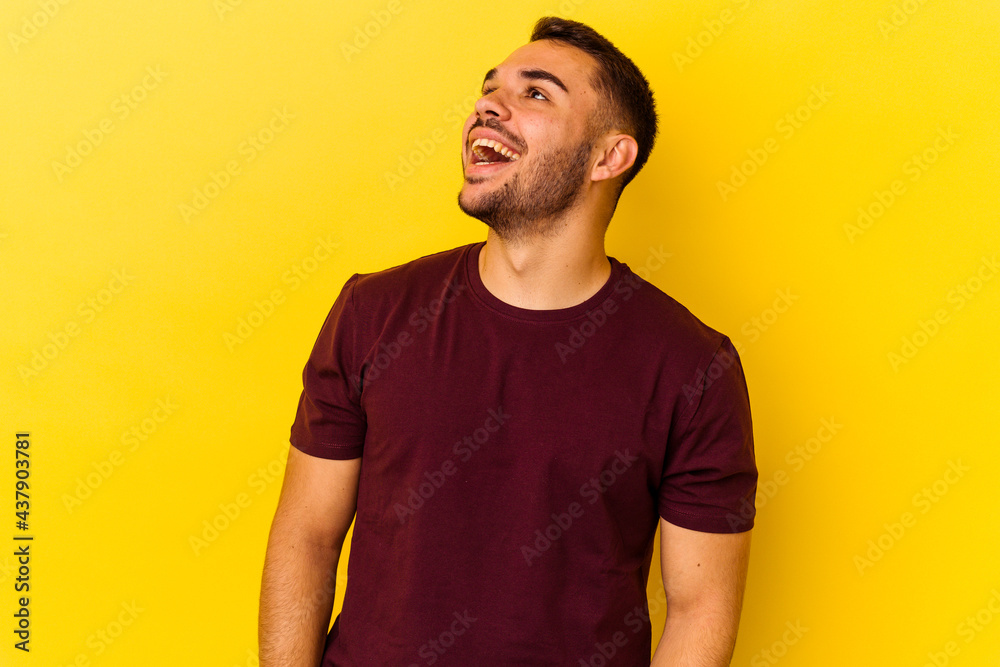 Young caucasian man isolated on yellow background relaxed and happy laughing, neck stretched showing teeth. Young caucasian man isolated on yellow background relaxed and happy laughing, neck stretched showing teeth.
