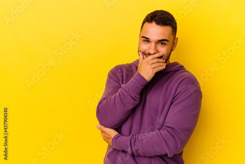 Young caucasian man isolated on yellow background laughing happy, carefree, natural emotion.