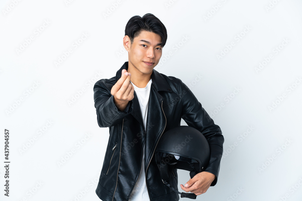 Chinese man with a motorcycle helmet isolated on white background making money gesture Chinese man with a motorcycle helmet isolated on white background making money gesture
