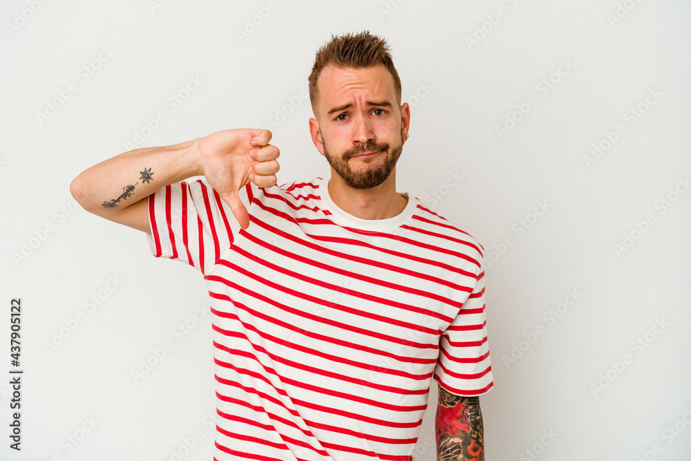 Young tattooed caucasian man isolated on white background showing thumb down, disappointment concept. Young tattooed caucasian man isolated on white background showing thumb down, disappointment concept.