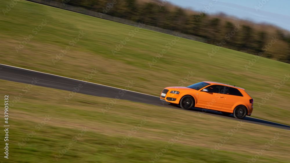 A panning shot of a racing car as it circuits a track.