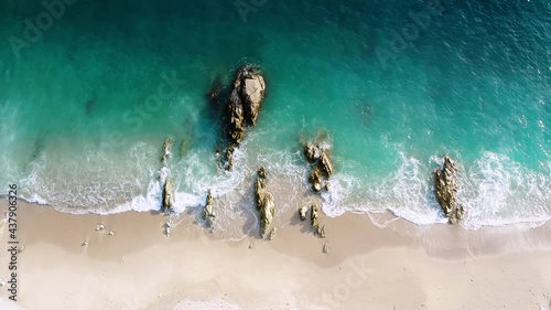 4K Aerial drone top down view bird eye view of sea blue waves break on rock and sand. Beatiful of sea water wave come to beach