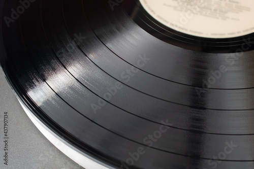 Part of vinyl record playing on old turntable. Detail of vinyl LP showing texture and music tracks