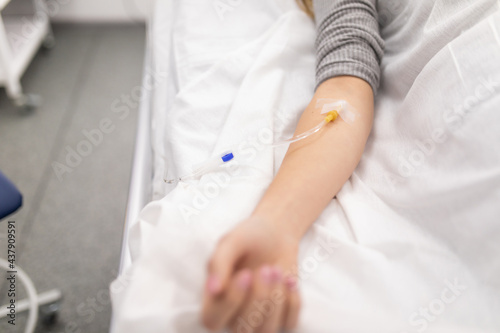 Hand of patient in serious condition is given a medicine through a dropper healthcare background with an intravenous system