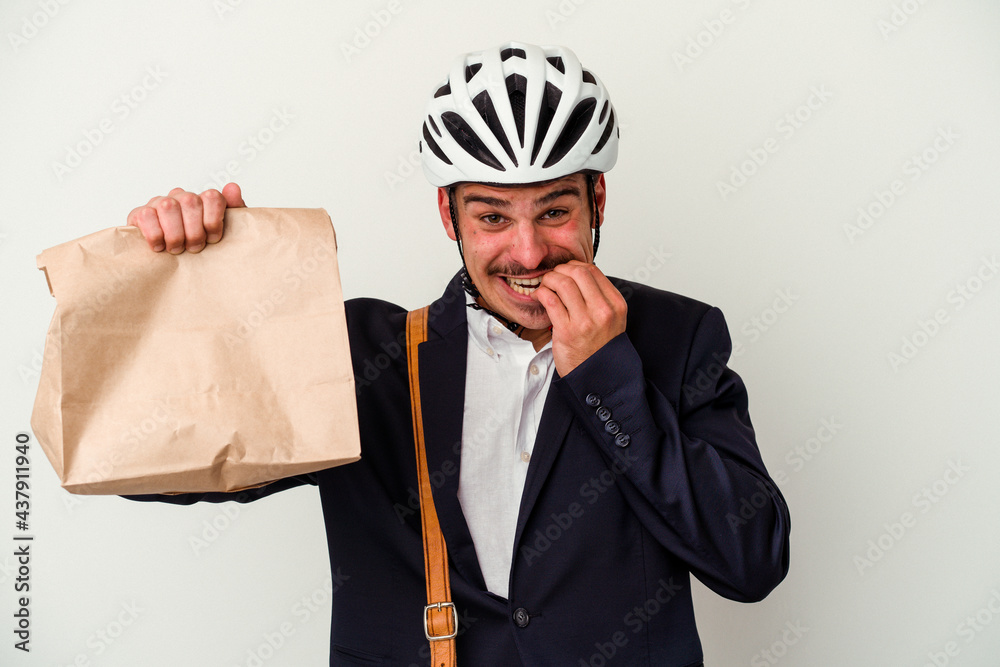Young business caucasian man wearing bike helmet and holding take way food isolated on white background biting fingernails, nervous and very anxious. Young business caucasian man wearing bike helmet and holding take way food isolated on white background biting fingernails, nervous and very anxious.