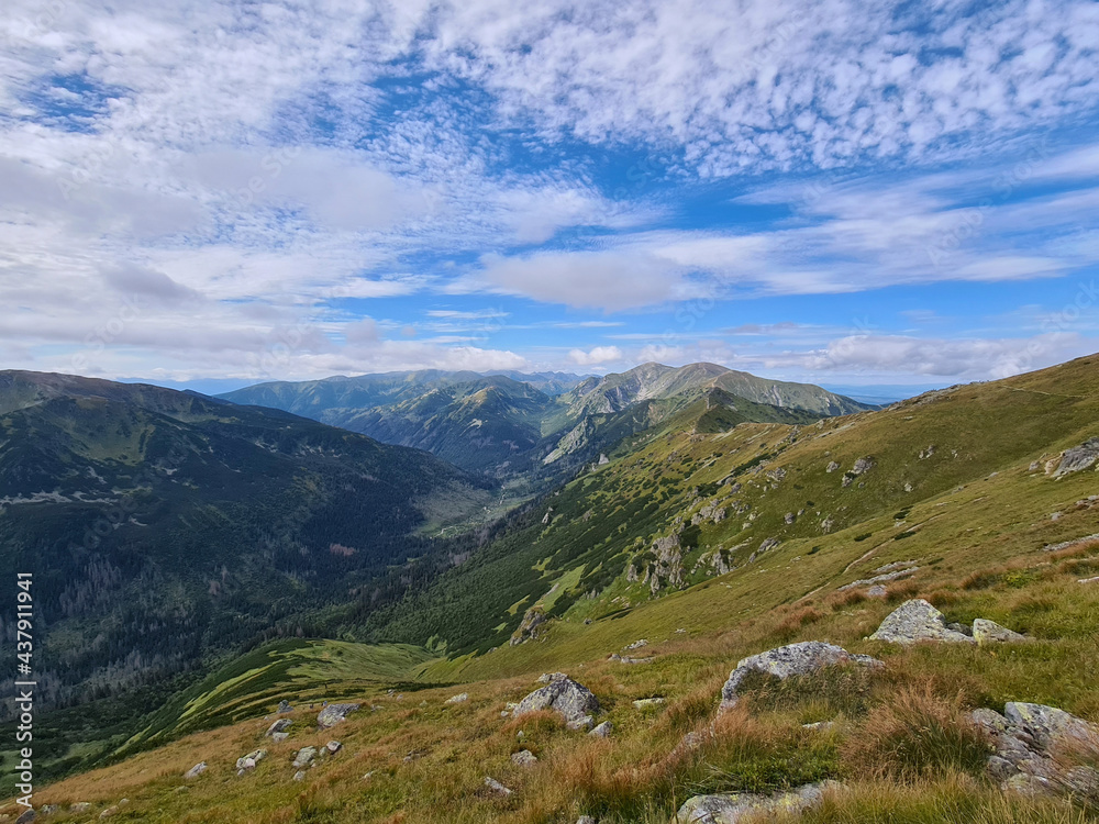 Natural landscape with blue sky and green mountains.