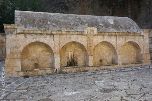 ‘Fountains of Pegeia’. Fountain with arches and a large water cistern at the paved square. Peyia (Pegeia), Cyprus. photo