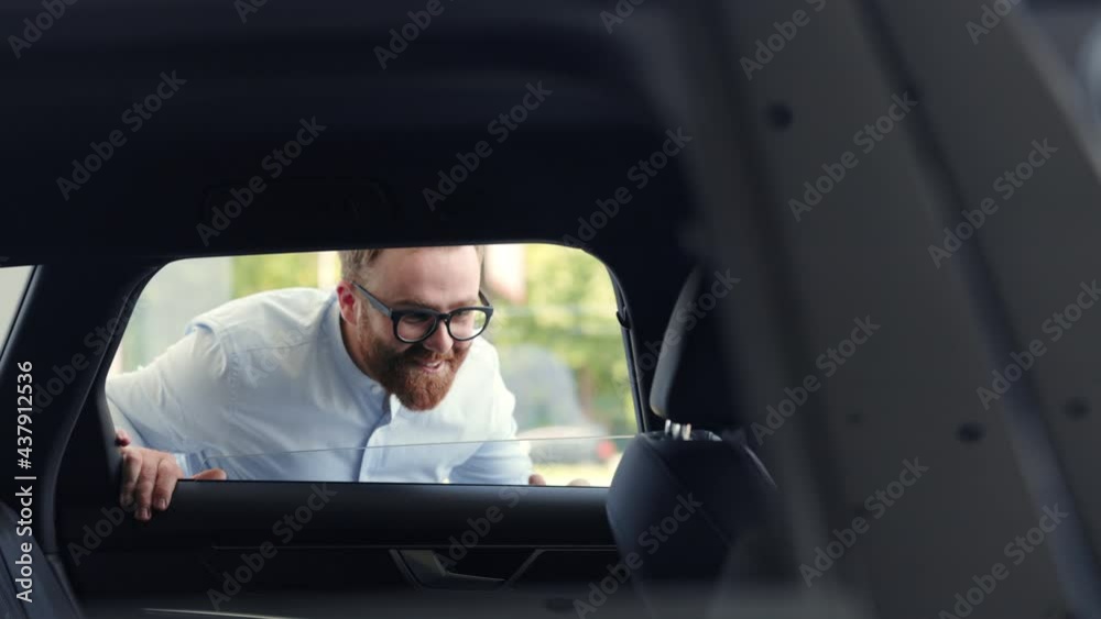 Man examining all details of new car before purchase Man examining all details of new car before purchase