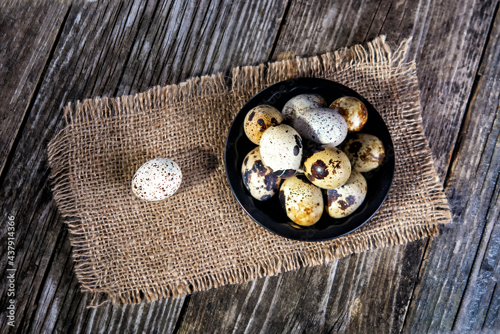 Quail eggs in a plate on a wooden background, top view Quail eggs in a plate on a wooden background, top view
